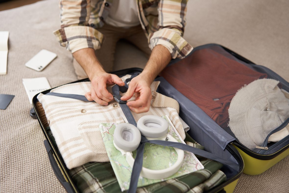Close up portrait male hands man putting clothes inside suitcase packing holiday