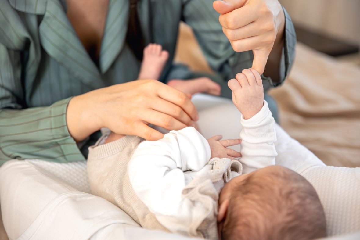 Mother plays with newborn baby newborn baby