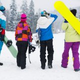 Two couples having fun snowboarding